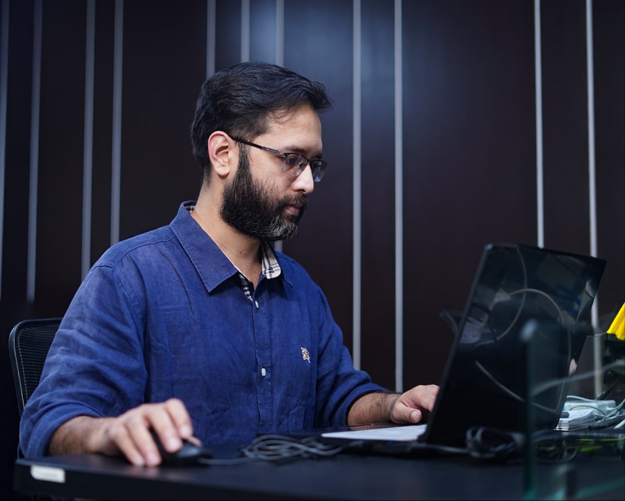 Product specialist working on a laptop in a bright workspace, representing a fully managed white-label blockchain delivery