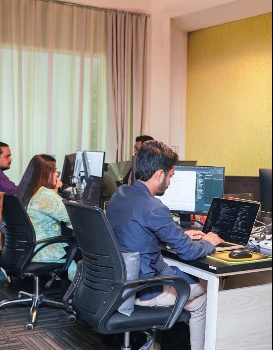A team collaborating around computers in a development studio.