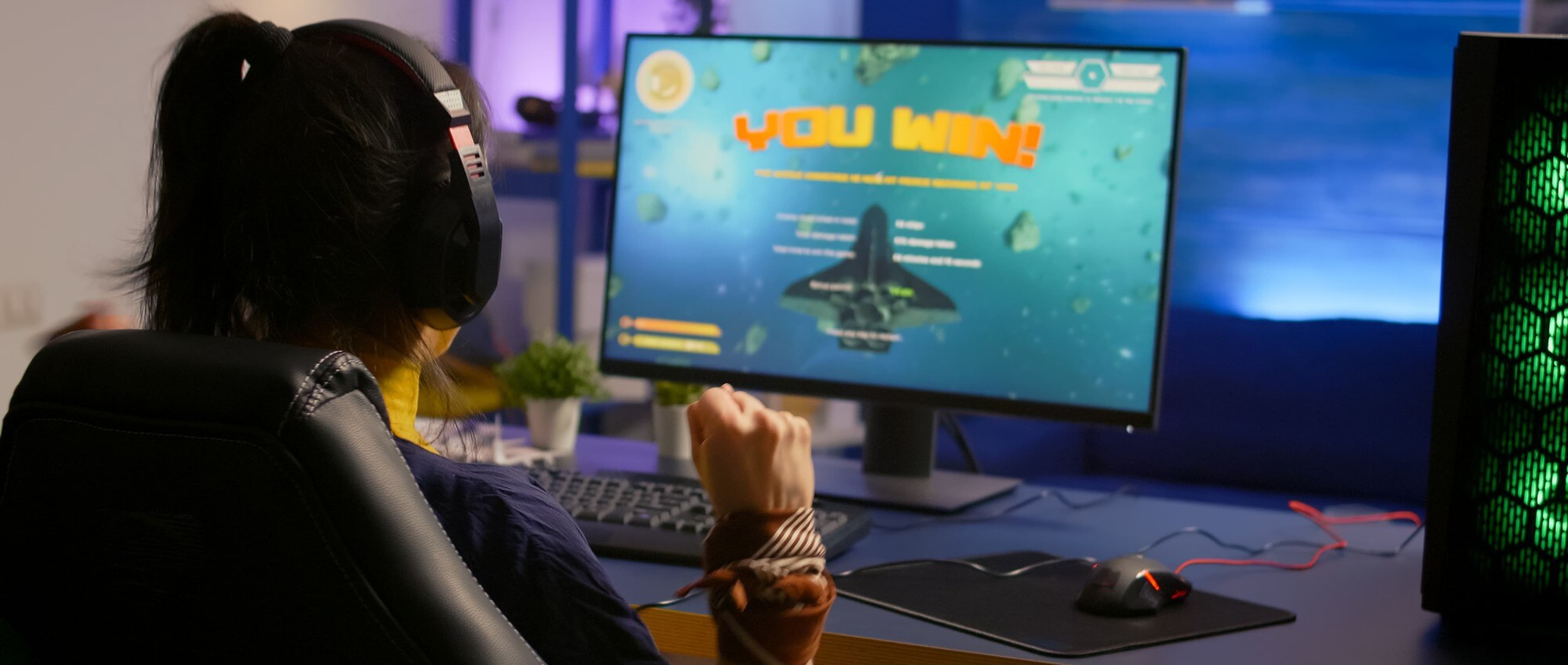 A gamer with headphones at a gaming desktop setup, representing immersive HTML5 game experiences.