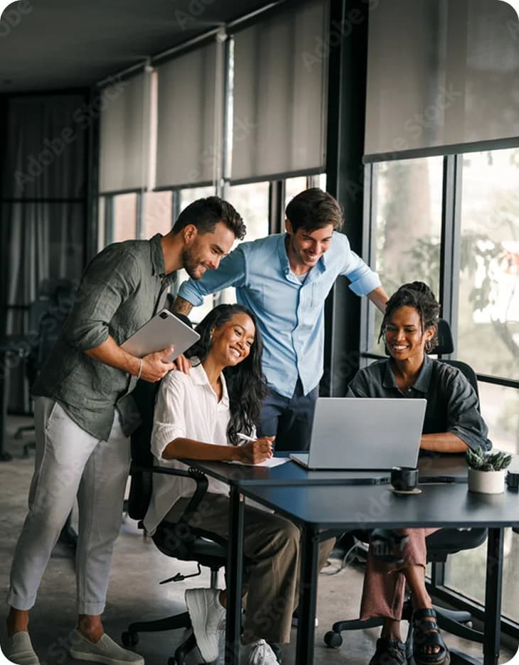 A team gathered around a laptop at a meeting table